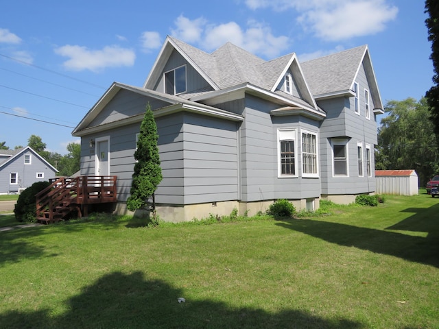 view of side of home with a deck and a lawn