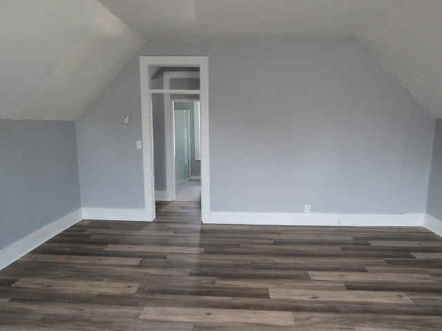 bonus room with lofted ceiling and dark wood-type flooring