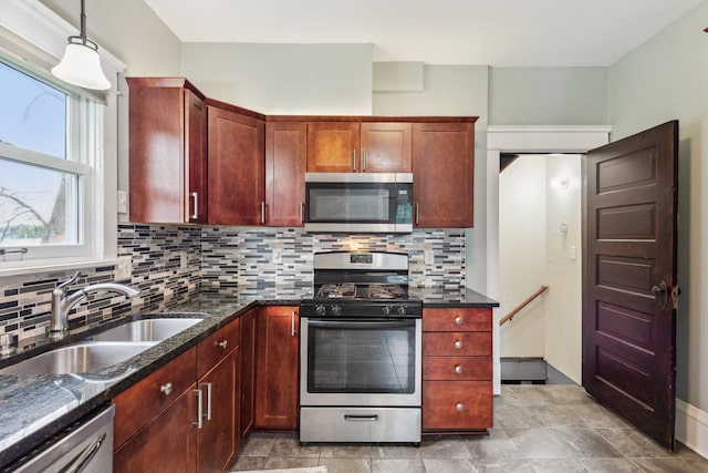 kitchen featuring appliances with stainless steel finishes, decorative light fixtures, decorative backsplash, sink, and light tile patterned floors