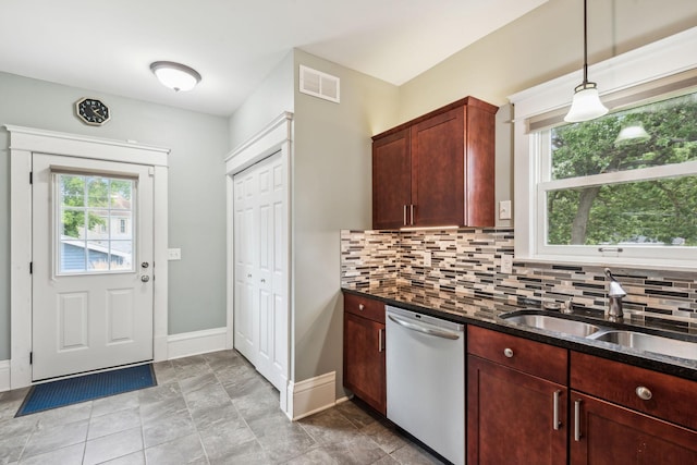 kitchen with decorative backsplash, dark stone countertops, white dishwasher, and light tile patterned floors