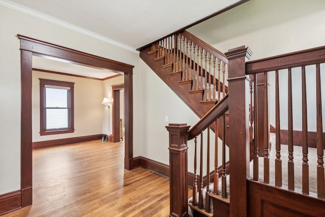 staircase with crown molding and hardwood / wood-style floors