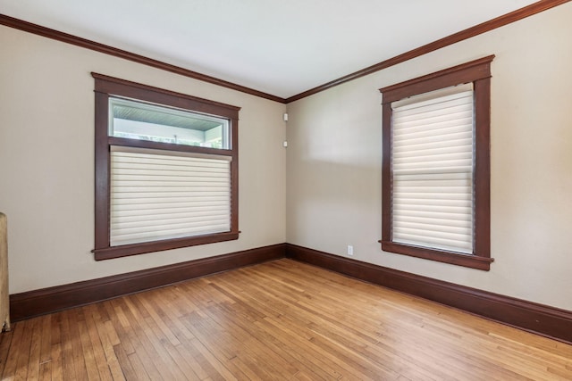 spare room featuring light hardwood / wood-style floors and ornamental molding