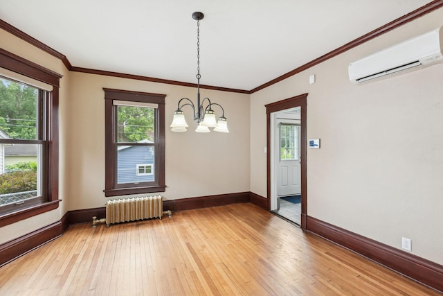 unfurnished dining area featuring an AC wall unit, ornamental molding, radiator, light hardwood / wood-style floors, and a notable chandelier