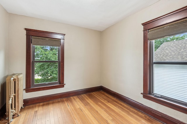 empty room with light wood-type flooring and radiator