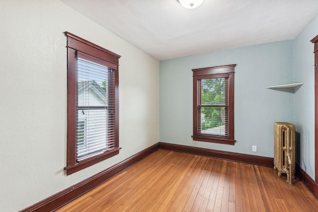 empty room featuring hardwood / wood-style flooring and radiator