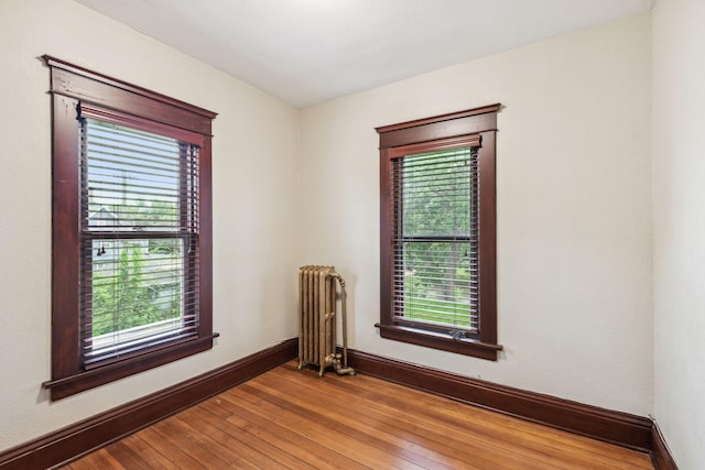 unfurnished room featuring hardwood / wood-style floors and radiator