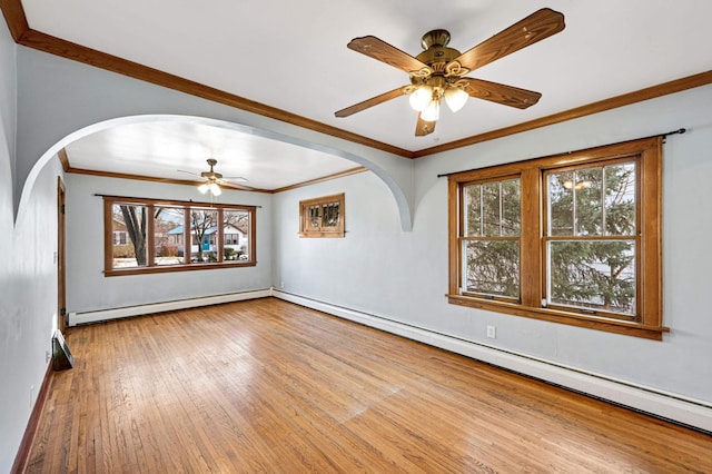 empty room featuring ceiling fan, light wood-type flooring, baseboard heating, and ornamental molding