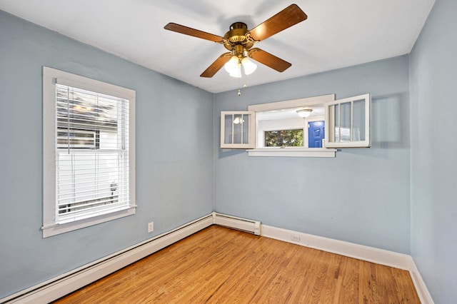 unfurnished room with light hardwood / wood-style floors, a baseboard radiator, a wealth of natural light, and ceiling fan