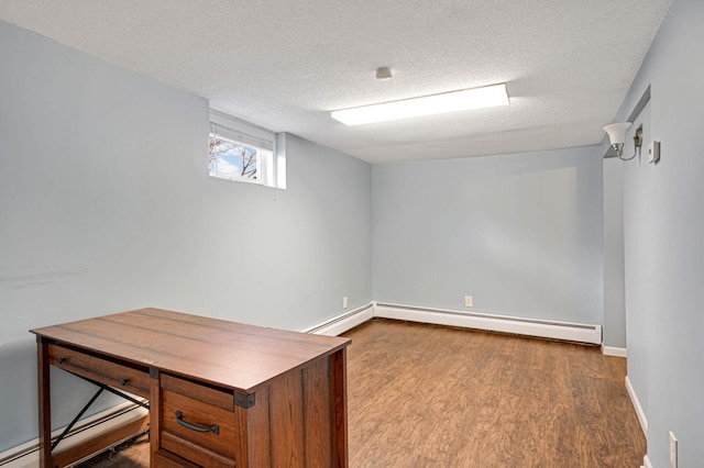 unfurnished office featuring baseboard heating, a textured ceiling, and hardwood / wood-style flooring