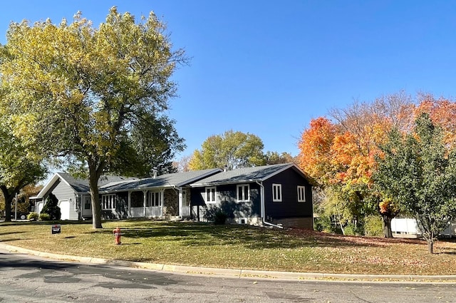 ranch-style home featuring a front lawn, a porch, and a garage