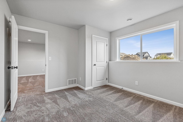 unfurnished bedroom featuring light carpet and a closet