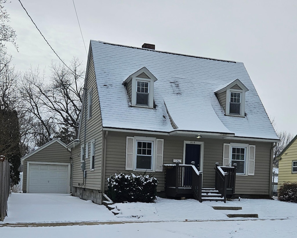 cape cod house with a garage and an outbuilding