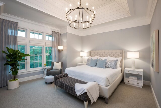 carpeted bedroom featuring a notable chandelier, a raised ceiling, baseboards, and ornamental molding