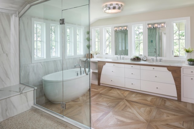 bathroom with a tub, plenty of natural light, parquet flooring, and tile walls