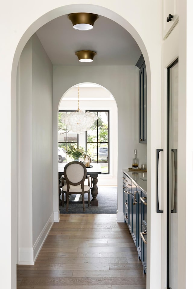 hall with baseboards and wood finished floors