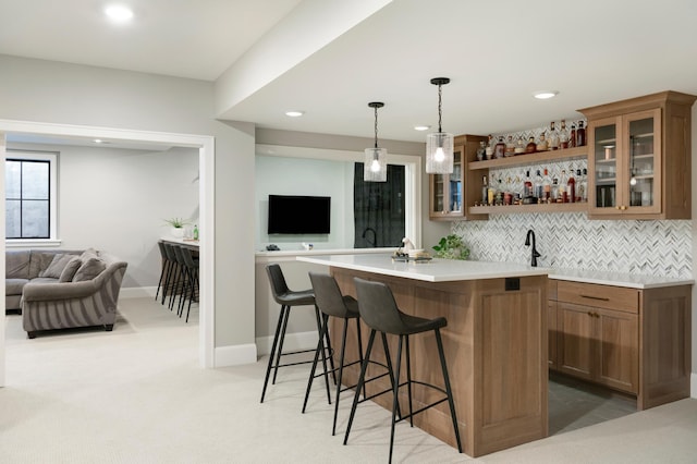 bar featuring backsplash, pendant lighting, and light colored carpet