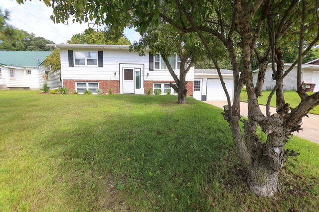 split foyer home featuring a garage and a front lawn