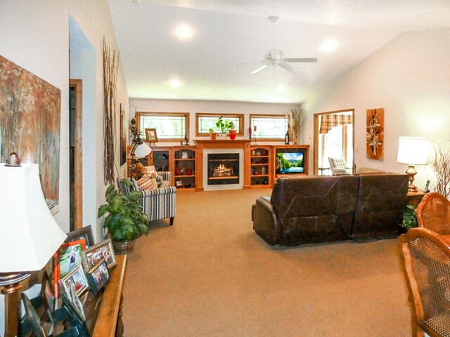 carpeted living room with ceiling fan and lofted ceiling