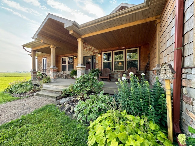 exterior space featuring stone siding and a porch