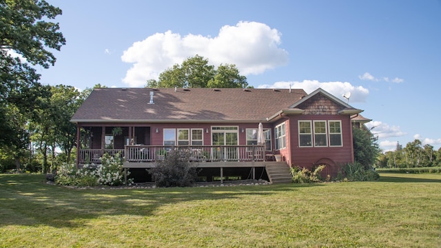 rear view of house with a deck and a yard