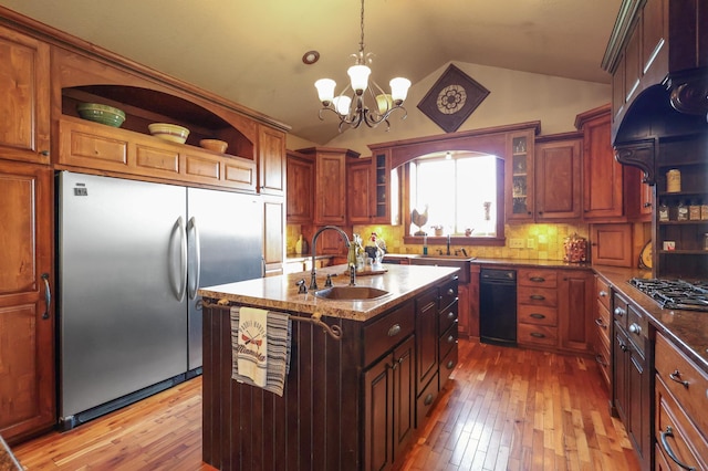 kitchen with a kitchen island with sink, vaulted ceiling, stainless steel appliances, open shelves, and a sink