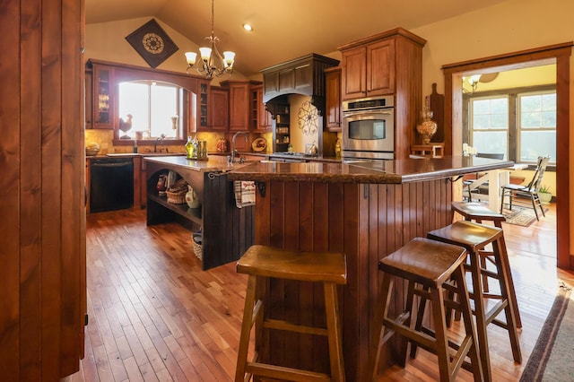 kitchen with plenty of natural light, black dishwasher, glass insert cabinets, and a kitchen breakfast bar