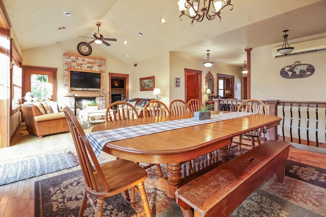 dining area featuring lofted ceiling, wood finished floors, ceiling fan with notable chandelier, a fireplace, and recessed lighting