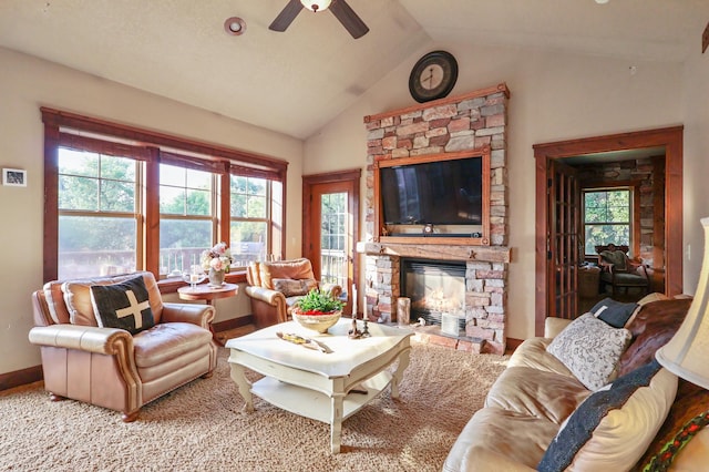 living area featuring a fireplace, baseboards, vaulted ceiling, and a wealth of natural light