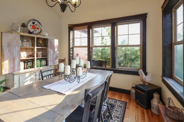 dining space with light wood finished floors, baseboards, and a notable chandelier