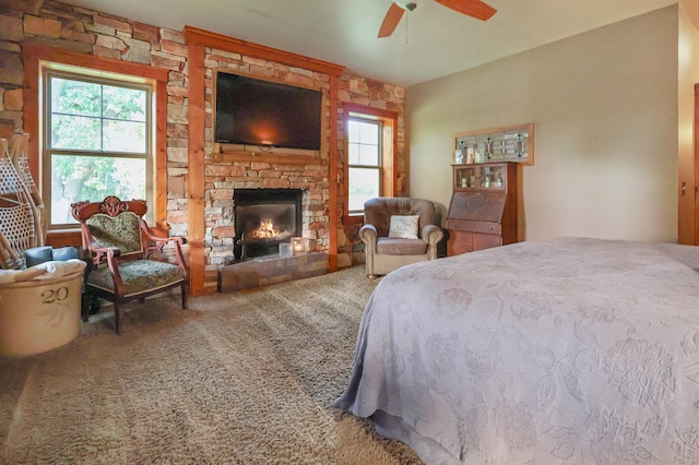 bedroom with carpet floors, a fireplace, and a ceiling fan