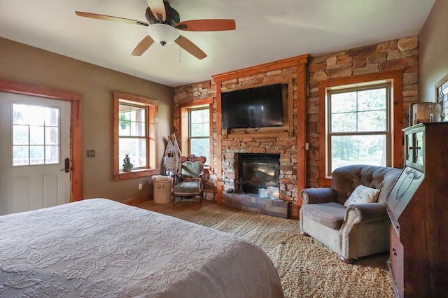 bedroom with ceiling fan and a fireplace