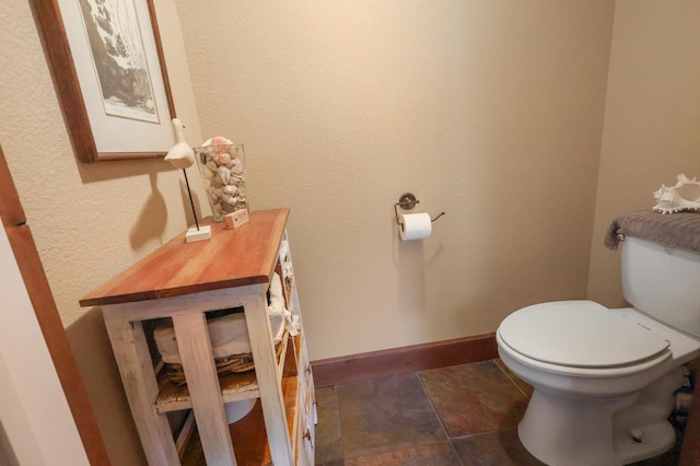 bathroom featuring baseboards and toilet