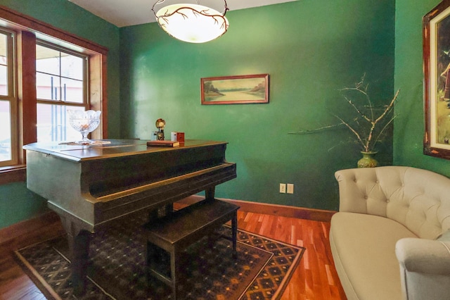 living area with baseboards and wood finished floors