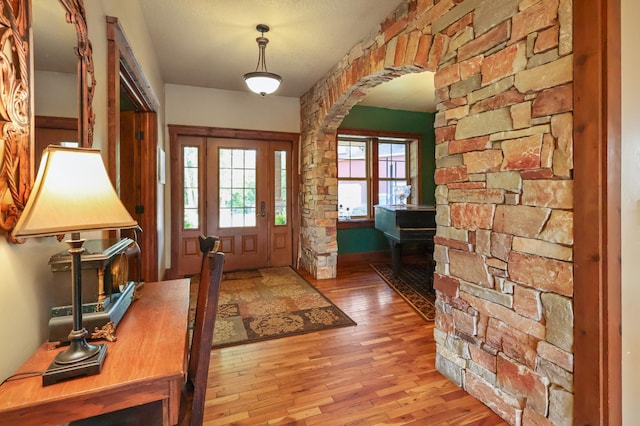 foyer featuring light wood-style floors and arched walkways