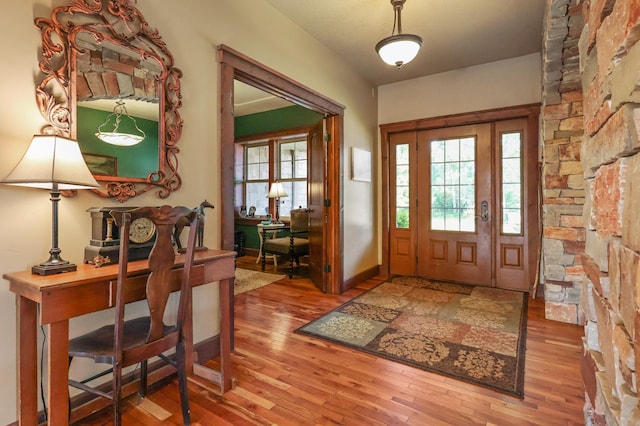 foyer entrance featuring baseboards and wood finished floors