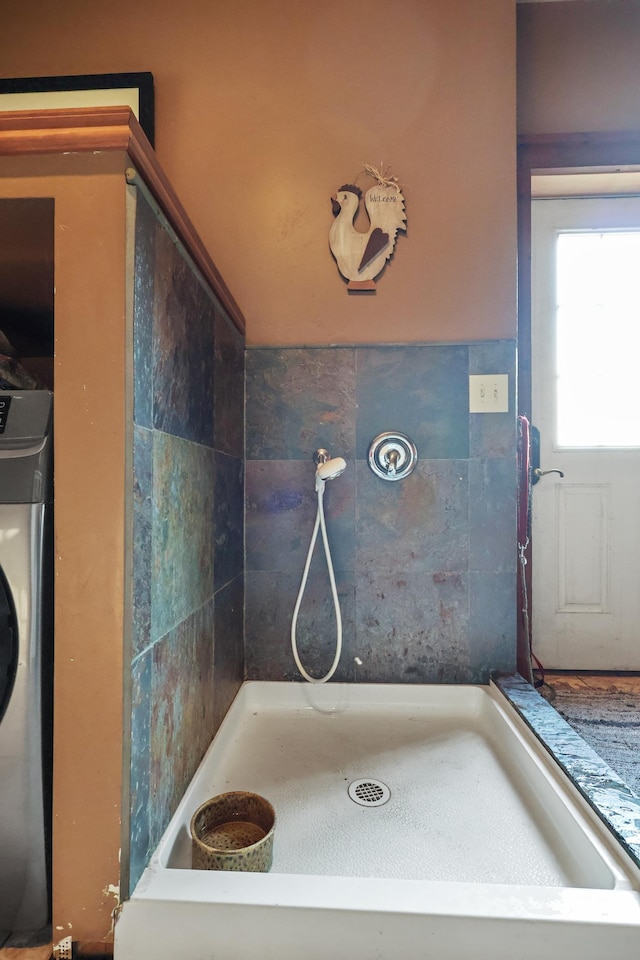 full bathroom featuring a shower stall and washer / clothes dryer