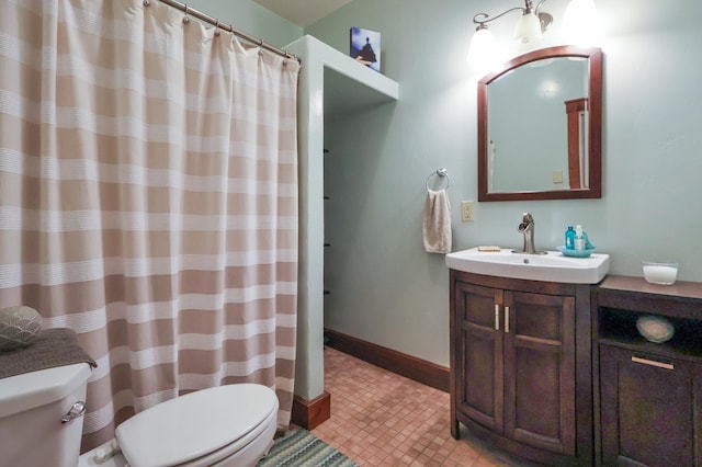 bathroom featuring toilet, baseboards, and vanity