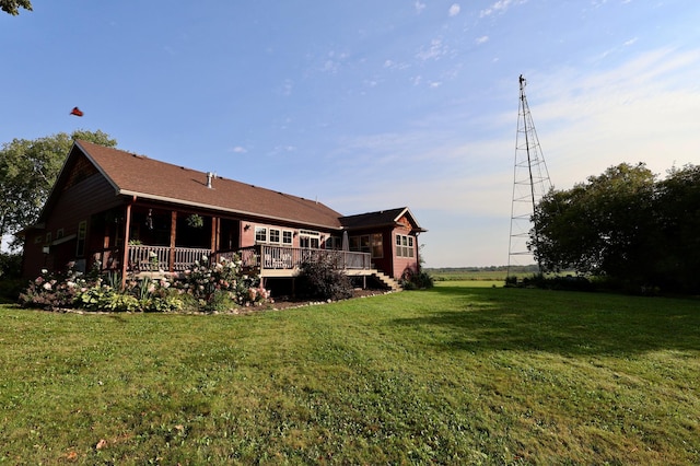 rear view of house featuring a yard and a wooden deck