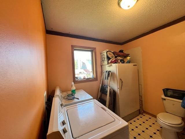 washroom featuring ornamental molding, a textured ceiling, and washer and clothes dryer