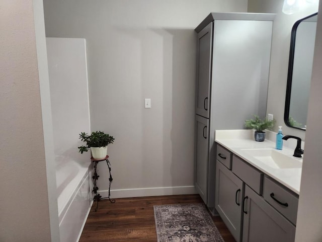 bathroom featuring vanity, baseboards, and wood finished floors