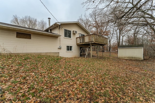 rear view of property featuring a shed and a deck