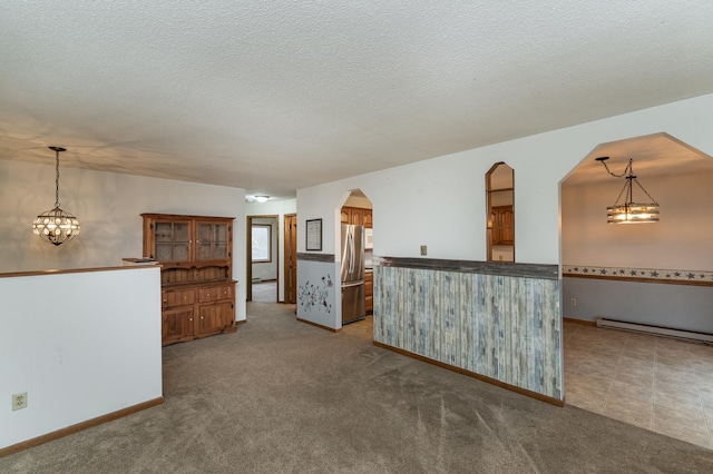 interior space with carpet flooring, a textured ceiling, and a baseboard heating unit