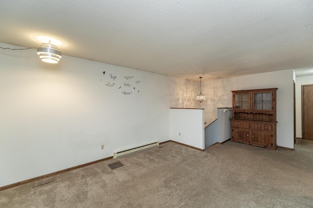 interior space with a textured ceiling, carpet floors, baseboard heating, and an inviting chandelier