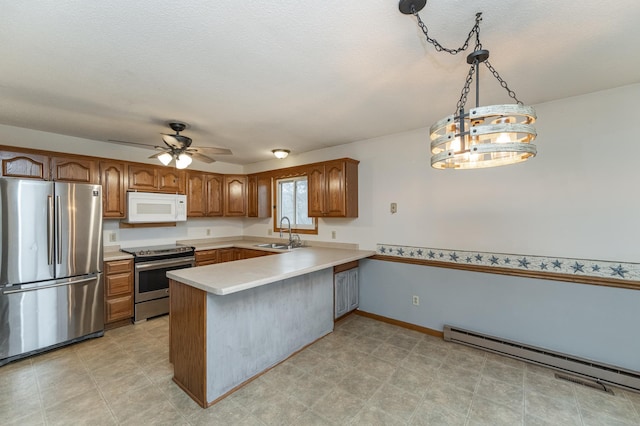 kitchen featuring sink, stainless steel appliances, baseboard heating, kitchen peninsula, and decorative light fixtures