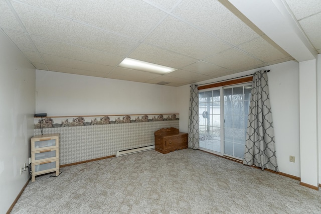 carpeted spare room featuring a paneled ceiling and a baseboard radiator