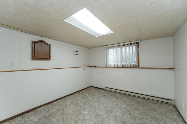 carpeted spare room with baseboard heating and a paneled ceiling