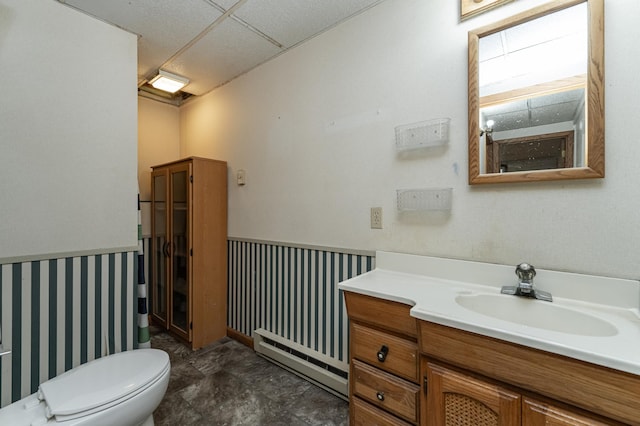 bathroom with toilet, vanity, and a baseboard heating unit