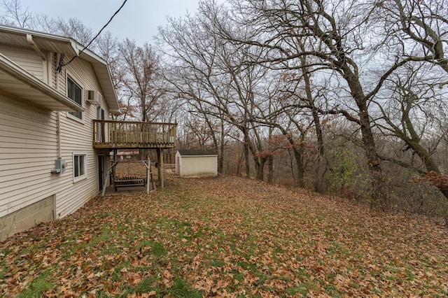 view of yard featuring a storage unit and a wooden deck