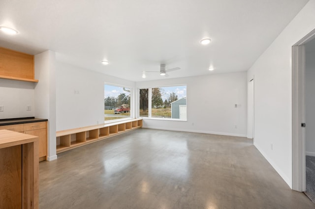 unfurnished living room with ceiling fan