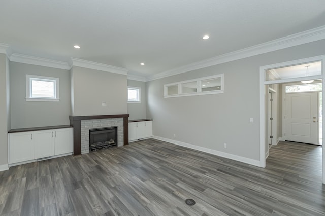 unfurnished living room featuring ornamental molding, dark wood-type flooring, and a fireplace